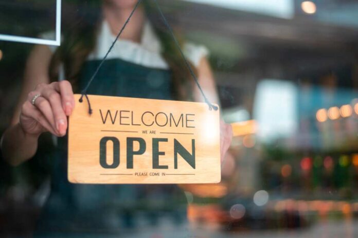 Woman,Entrepreneur,With,Open,Sign,In,Cafe,Shop,,,Small