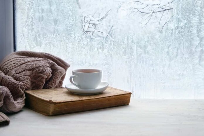 Winter,Background.,Tea,Cup,,Book,,Sweater,And,Winter,Frozen,Window.
