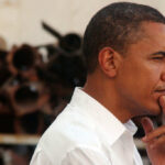 Profile view of a man in a white shirt with a thoughtful expression