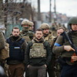 A group of military personnel in tactical gear walking through an urban area