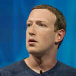 Individual speaking at a technology conference with a focused expression