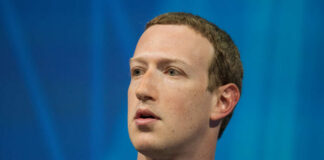 Individual speaking at a technology conference with a focused expression
