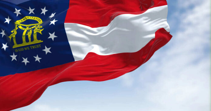 Georgia state flag waving against a blue sky