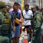 U.S. Border Patrol officers interacting with a group of individuals at the border