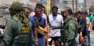 U.S. Border Patrol officers interacting with a group of individuals at the border