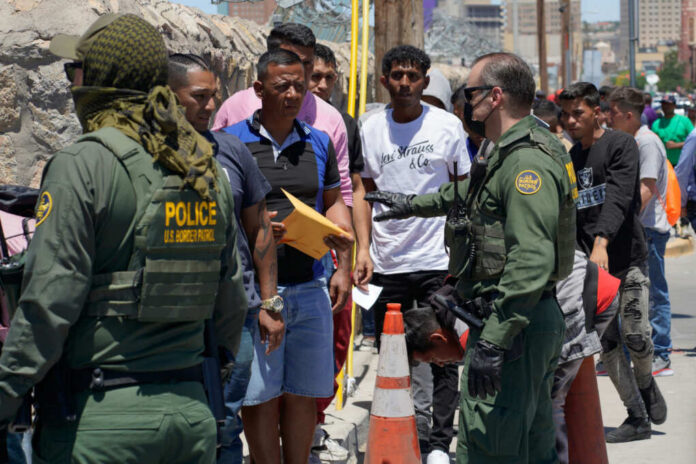 U.S. Border Patrol officers interacting with a group of individuals at the border