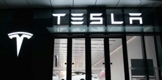 Tesla showroom featuring a white electric vehicle displayed under bright lights