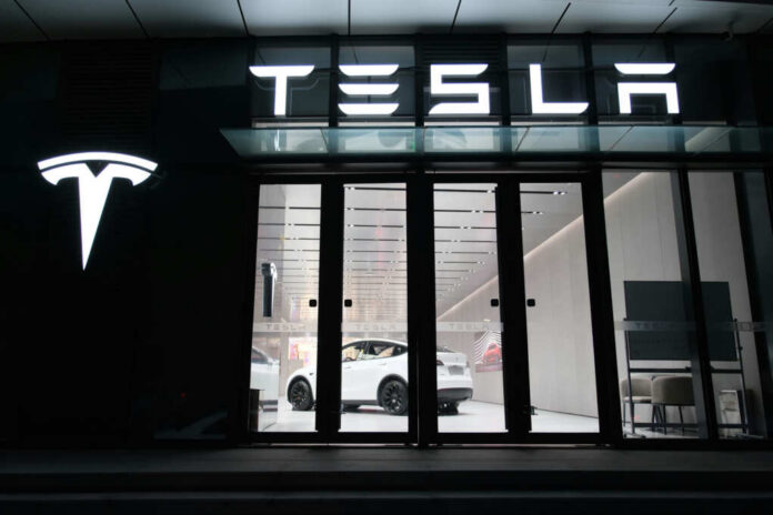 Tesla showroom featuring a white electric vehicle displayed under bright lights