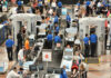 Busy airport security checkpoint with travelers and TSA agents