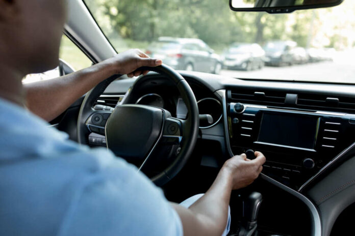 Drivers hands on the steering wheel inside a car