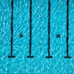 Aerial view of a swimming pool with clear blue water and lane markers