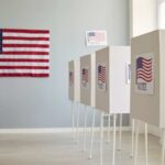 Voting booths with American flags in a polling place