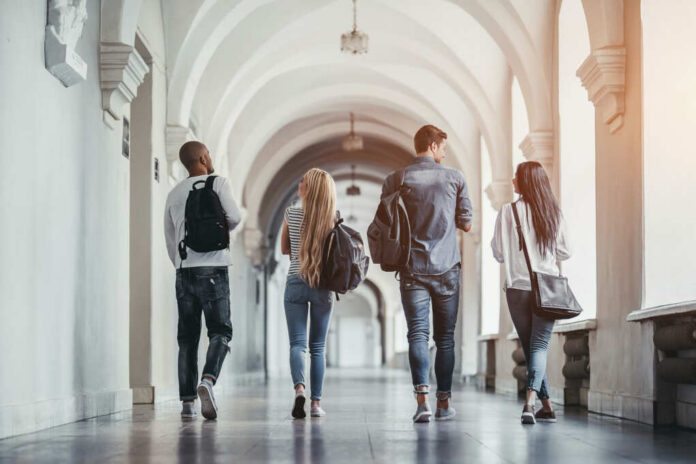 Group of students walking together in a university hallway