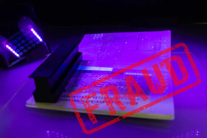 A passport under UV light with a stamp indicating fraud
