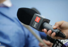 A hand holding a CNN microphone during a news interview