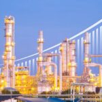 Illuminated industrial oil refinery with a growth graph overlay