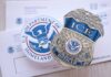 ICE badge and U.S. Department of Homeland Security emblem on official documents