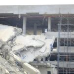 Damaged building structure with exposed debris and scaffolding