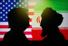 Silhouettes of two figures against the backgrounds of the American and Iranian flags