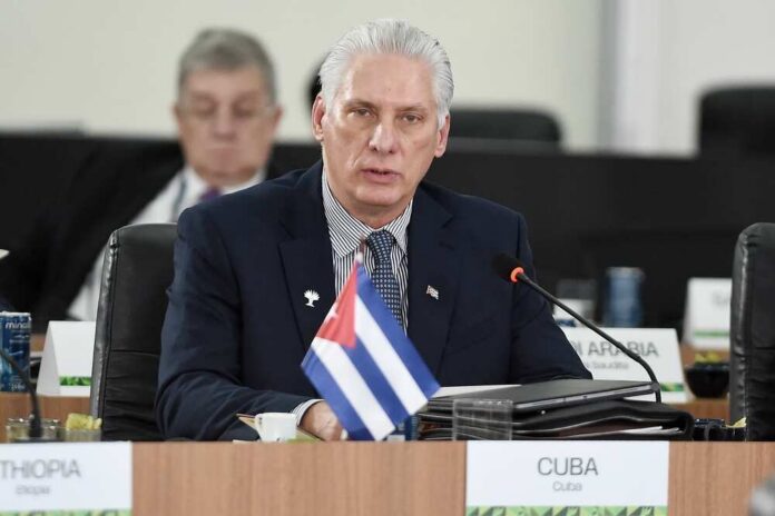 Cuban official speaking at a conference with a flag in front
