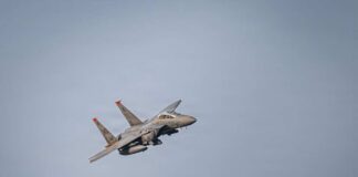 A military fighter jet flying against a clear sky