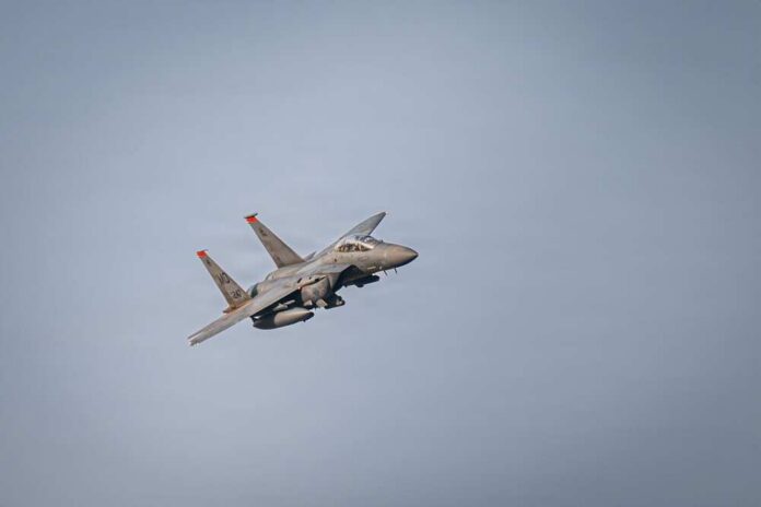 shutterstock_2716689565.jpg A military fighter jet flying against a clear sky