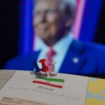 Map of Iran with push pins and a blurred figure in the background