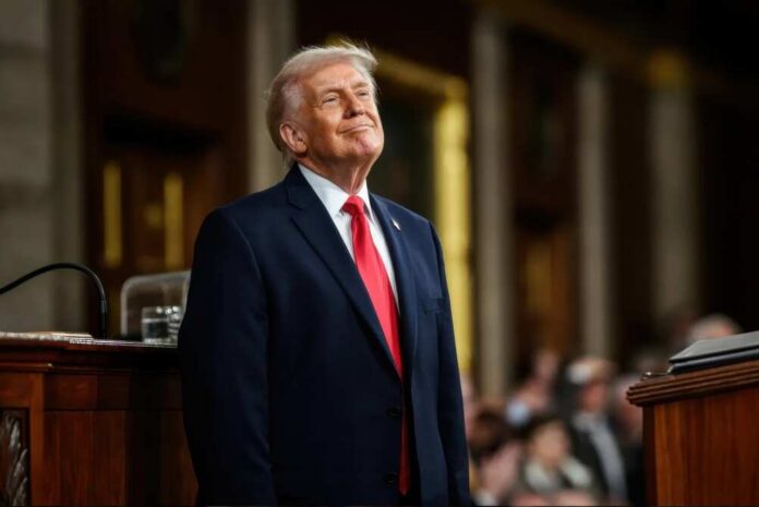 A man in a suit smiling while standing at a podium during a formal event