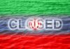 Graphic representation of the word 'CLOSED' overlaid on the Iranian flag with a water background