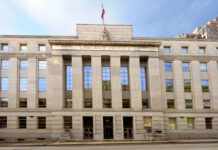 Facade of a government building with the words Law and Justice and a statue on top