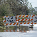 Flooded road with road closure signs and traffic barriers