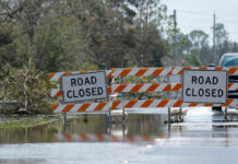 Flooded road with road closure signs and traffic barriers