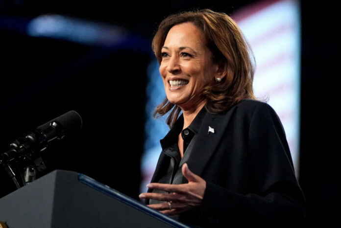 shutterstock2526657049jpg A woman smiling while speaking at a podium with a microphone