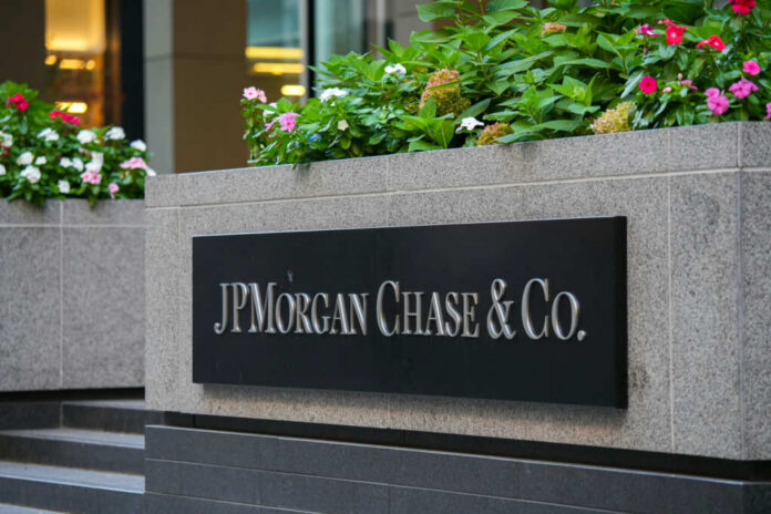 Sign of JPMorgan Chase & Co. in front of a corporate building with flowers