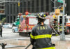 Tunnel Fire Cripples Northeast Commutes Firefighter in FDNY uniform overseeing emergency response at a city intersection