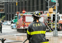 Tunnel Fire Cripples Northeast Commutes Firefighter in FDNY uniform overseeing emergency response at a city intersection