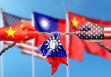 Hands painted with flags of China and the USA pulling a torn Taiwan flag