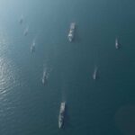 Aerial view of multiple naval ships navigating in the ocean