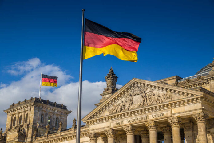 German flag flying in front of the Reichstag building in Berlin