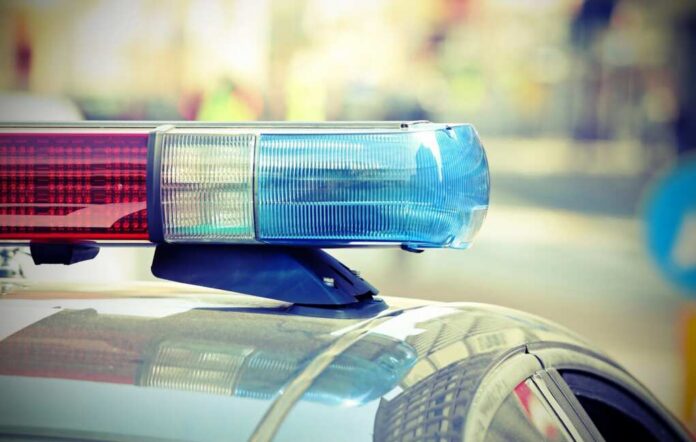 Flashing,Lights,Of,The,Police,Car,Into,The,Checkpoint,In Close-up of a police cars light bar with blue and red lights
