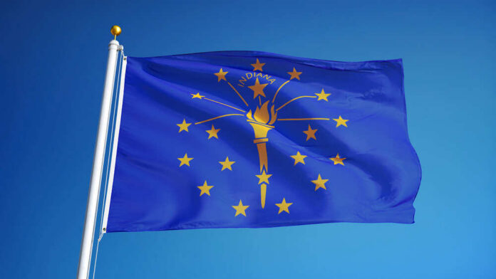 Indiana state flag waving against a blue sky