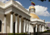 Mystery Strike: Trump Claims Gang Kingpin Down Exterior view of a government building with a golden dome and Venezuelan flag