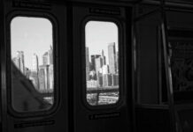 View of a city skyline through subway windows in black and white