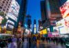 Times Square Chaos: Teen Shot, Mayhem Erupts Crowd of people in Times Square surrounded by bright advertisements and buildings