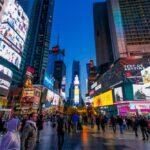 Crowd of people in Times Square surrounded by bright advertisements and buildings