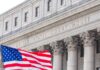 Citizenship Bombshell Hits Supreme Court Facade of a United States courthouse with an American flag in the foreground