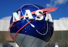 Taxpayers Fume Over NASA Goalposts NASA logo displayed on a large blue globe against a clear sky
