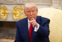 On-Camera Meltdown: Trump Walks Out A man in a blue suit and red tie pointing while seated