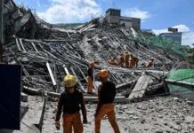 Rescue workers search a collapsed building site