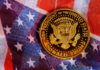 Coin Loophole? Trump Dollar Sparks Fury A commemorative coin featuring the presidential seal and the name Donald Trump on an American flag background